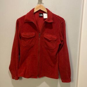 The North Face woman’s red/orangeish zip up fuzzy jacket